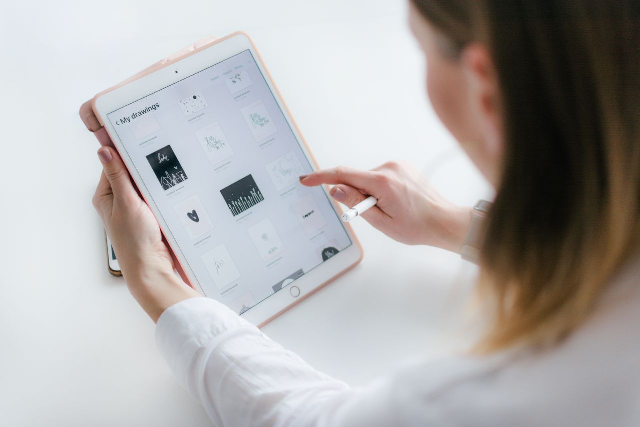 Crafting Captivating Headlines: Your awesome post title goes here A woman interacts with a tablet to create digital art. Ideal for technology and creativity concepts.